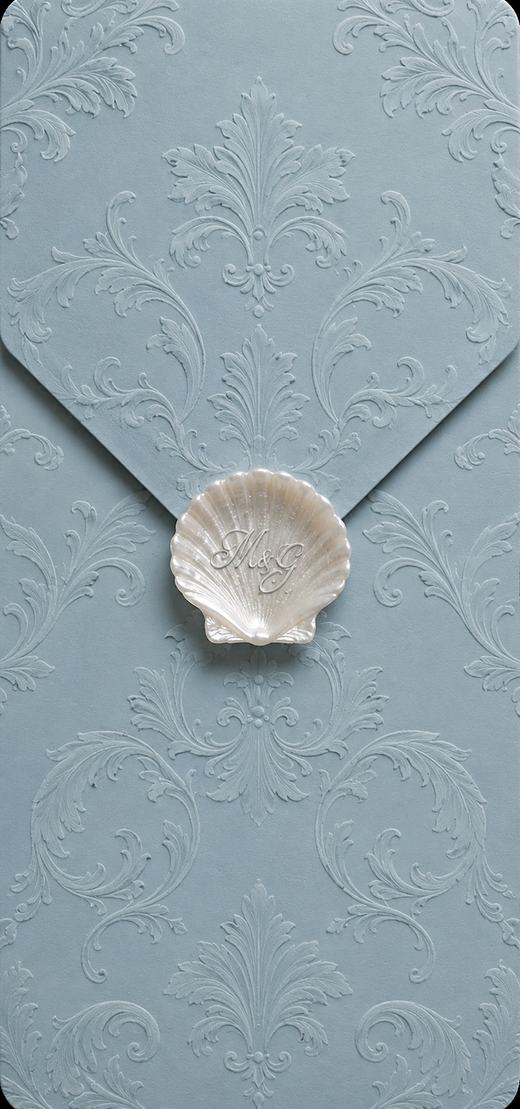 The Coastal Collection digital wedding invitation — pale blue embossed envelope with a shell seal
